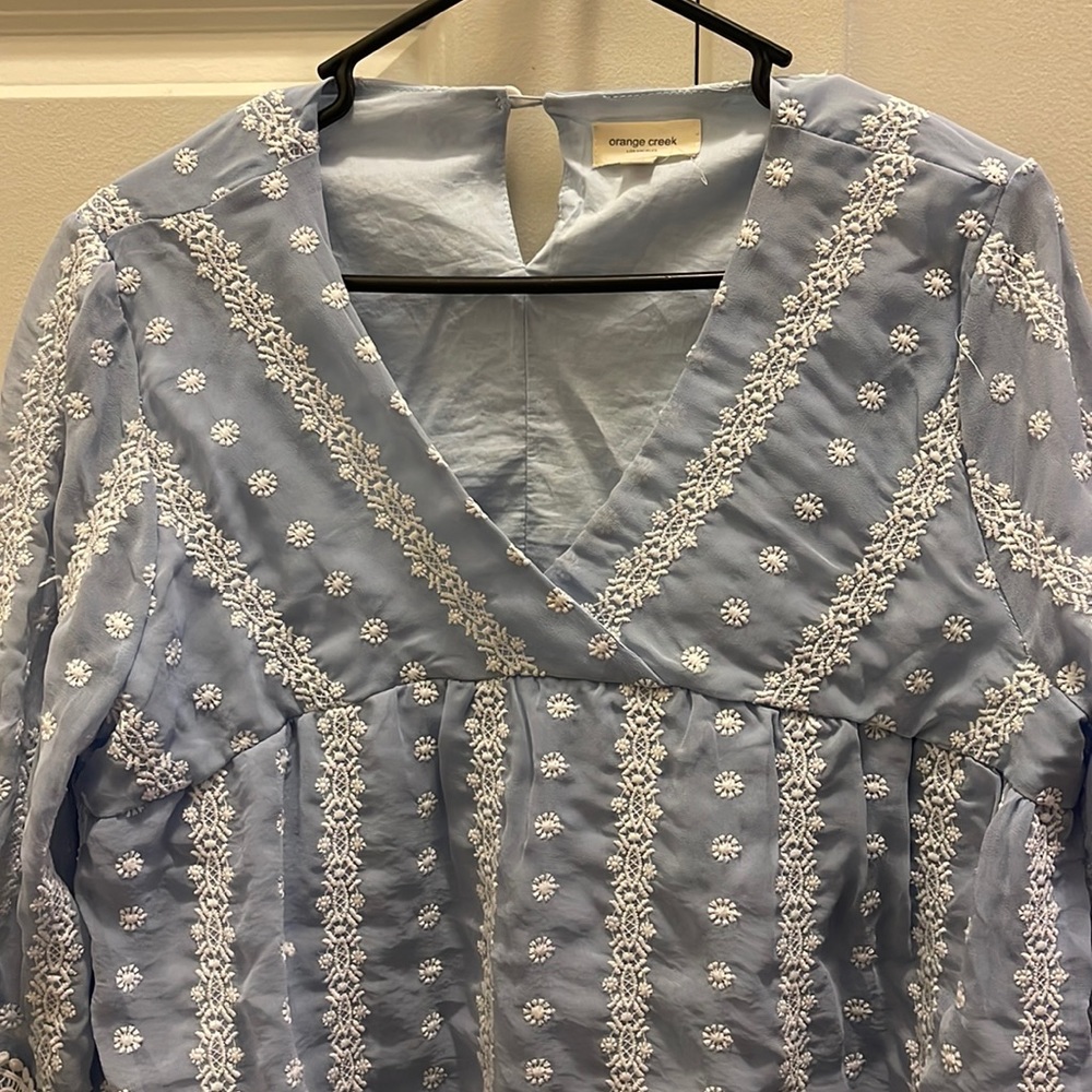Light blue with embroidered white flowers maternity shirt.